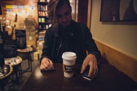 young man drinking takeaway coffee 