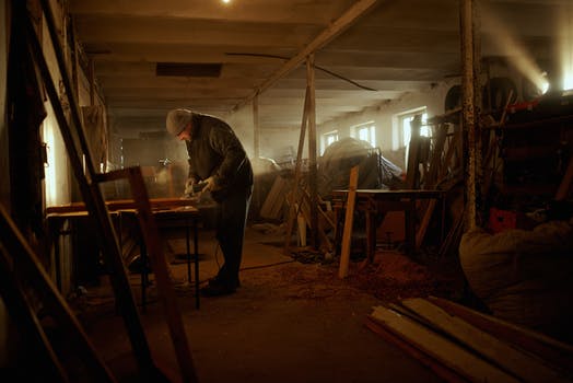 man restoring wooden furniture in shed