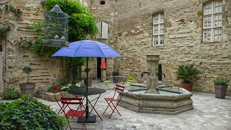 Patio umbrella, tables and chairs in a courtyard